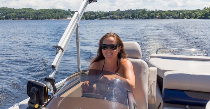 Woman piloting a pontoon boat